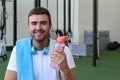 Man using a reusable plastic water bottle at the gym