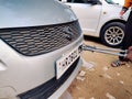 Man using a riveting locking tool to affix a tamper proof HSRP high security registeration plate to a maruti swift car