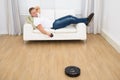 Man using robotic vacuum cleaner remote control Royalty Free Stock Photo