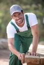 man using roller to apply wood treatment