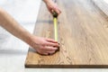 Man using roulette tape and checking size of wooden table top Royalty Free Stock Photo