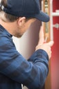 man using screwdriver to adjust door hinge Royalty Free Stock Photo