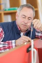 Man using screwdriver to adjust door hinge Royalty Free Stock Photo