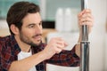 man using screwdriver to secure seal between two metal tubes Royalty Free Stock Photo