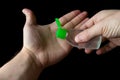 Close up view of a person applying hand sanitiser gel to their hands, isolated against a black background