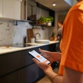 Man using a smart home water leak detection app in the kitchen Royalty Free Stock Photo