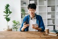 Man using smart phone for mobile payments online shopping,omni channel,sitting on table Royalty Free Stock Photo