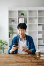 Man using smart phone for mobile payments online shopping,omni channel,sitting on table Royalty Free Stock Photo