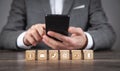 Man using smartphone. Contact symbols on wooden cubes