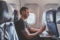 Man using a smartphone while flying in a plane. Royalty Free Stock Photo