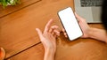 A man using smartphone at his office desk. Phone white screen mockup in a male`s hand Royalty Free Stock Photo