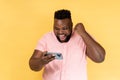 Man using smartphone and playing mobile game with excited positive face, happy to win, clenched fist Royalty Free Stock Photo