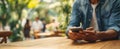 The man using a smartphone in a vibrant outdoor cafe setting..AI generated image Royalty Free Stock Photo