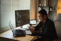 Man using smartphone after working with laptop on table, businessman using mobile phone to search or social media or shopping