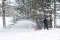 Man using snow blower machine to clear driveway. Royalty Free Stock Photo