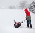 Man using snow blower on snowy drive Royalty Free Stock Photo