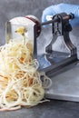 Man using spiralizer to cut apple into strips.