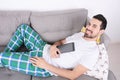 Man using tablet on couch. Royalty Free Stock Photo