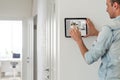 man using tablet panel application for control smart home living. Blonde female touch Wireless device controller for Royalty Free Stock Photo