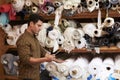 Man using tablet selects fabric from storage shelves Royalty Free Stock Photo