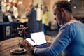 Man using tech gadgets in cafe