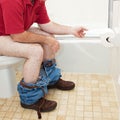 Man Using Toilet Paper in Bathroom Royalty Free Stock Photo