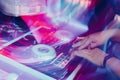 Man is using a turntable to spin music at an upbeat party atmosphere.