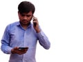 Man using two mobile phones talking and typing on cell, Indian men in Blue sthit Isolated on White background Royalty Free Stock Photo