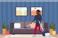 Man using vacuum cleaner african american guy vacuuming couch doing housework housekeeping cleaning service concept Royalty Free Stock Photo