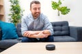Man using virtual assistant and smart speaker at home Royalty Free Stock Photo