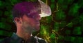 Man using VR headset exploring digital interface with abstract green graphics