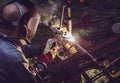 Man using welding machine stick to cut melt iron metal construction outdoors. Royalty Free Stock Photo