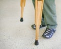 Man using wood crutches on terrazzo floor background