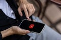 A man using Youtube application on his iPhone while sitting outdoors. close-up image Royalty Free Stock Photo