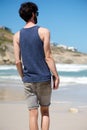 Man on vacation walking alone on beach with book Royalty Free Stock Photo