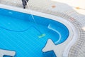 Man vacuuming the bottom of the pool. Pool cleaning