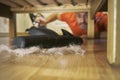 Man vacuuming a floor under a bed Royalty Free Stock Photo