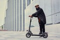 A man vaping and riding by electric scooter. Royalty Free Stock Photo