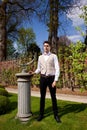 Man in Vicorian clothing, pillar and sundial in the park