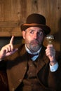 The man in the Victorian costume holds the incandescent bulb in one hand and shows a gesture of attention with the other.