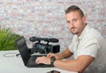 Man video editor with laptop and professional video camera Royalty Free Stock Photo