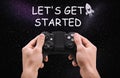 Man with video game controller and phrase LET`S GET STARTED against night sky Royalty Free Stock Photo