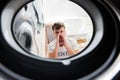 Man view from washing machine inside. Male does laundry daily routine. ÃÂ¡losed his nose from the unpleasant smell