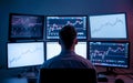 A man, viewed from behind, sitting in front of a desk with multiple computer monitors. Royalty Free Stock Photo