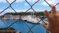 Man views yachts behind fence, corrupt official looks at confiscated property