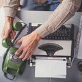 Man in vintage office uses green rotary telephone from above