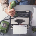 Man in vintage office uses green rotary telephone from above