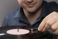 A man and vintage record player while recording, the record spins and music plays. Gramophone and antiquity idea