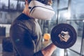 Man in virtual reality headset exercising with dumbbell in gym Royalty Free Stock Photo