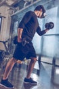 Man in virtual reality headset exercising with dumbbells in gym Royalty Free Stock Photo